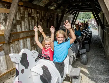 Kids riding cow-themed barrel train through covered tunnel at Corn Cob Acres, Lancaster PA