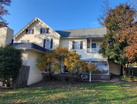 Rear exterior of Apple Bin Inn Bed and Breakfast with a fall garden and enclosed sunporch