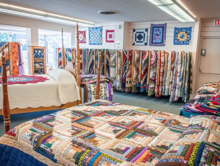 Handmade quilts displayed on beds and walls at The Quilt Shop at Miller's in Lancaster PA