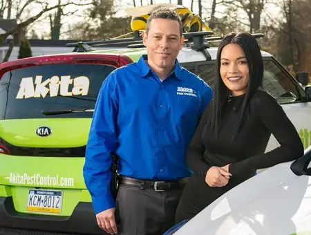 Akita Pest Control owners standing in front of branded service vehicles in Lancaster PA