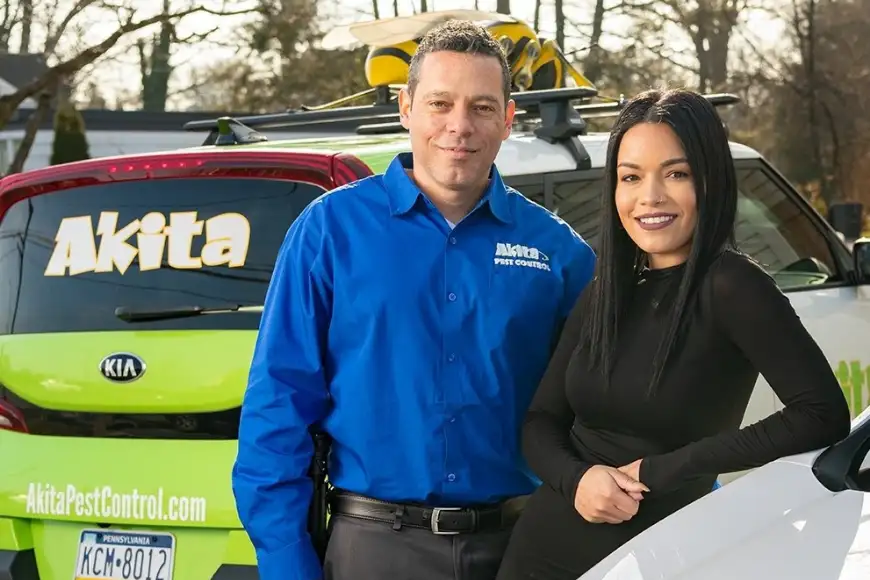 Akita Pest Control owners standing in front of branded service vehicles in Lancaster PA