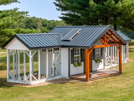Custom white chicken coop with solar panel and covered porch from The Hen House Collection in Lancaster PA