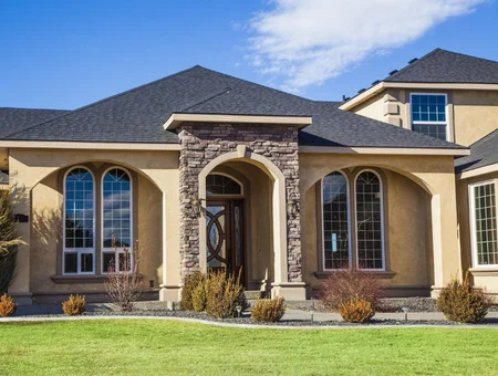 Dark gray architectural shingle roof on stucco home with stone archway entrance by Indian Run Roofing in Lancaster PA
