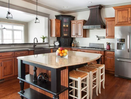 Custom kitchen with honey oak cabinets, granite island, and dark range hood by Kauffman Kitchens in Lancaster PA
