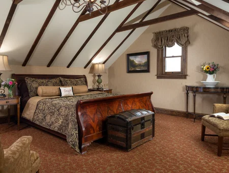 Sleigh bed suite with vaulted beamed ceiling and antique trunk at Inn and Spa at Leola Village