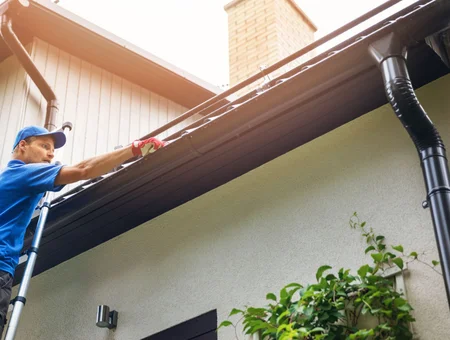 Octorara Roofing and Exteriors technician installing gutters on residential home in Lancaster PA