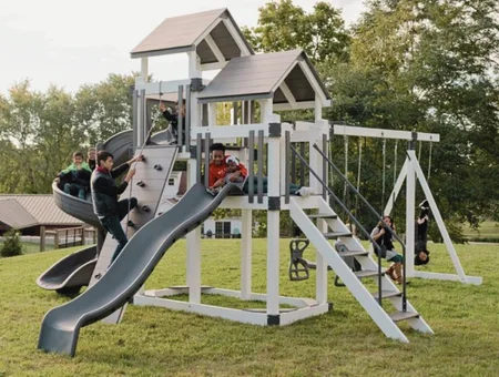 White vinyl backyard swing set with slide and climbing wall from Lancaster Swing Sets and Outdoor Fun in Lancaster PA