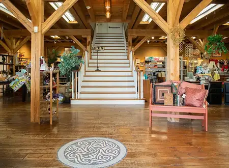 Rustic wood beam interior of Freedom Thrift store with staircase and hardwood floors in New Holland Lancaster PA