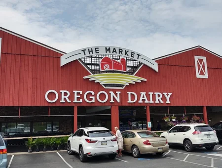 Exterior of Oregon Dairy market building with red barn facade and parking lot