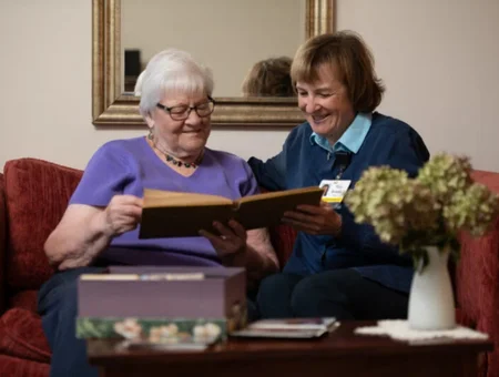 Home care companion looking through photo album with senior client by Graceful Transitions by Landis at Home in Lancaster PA