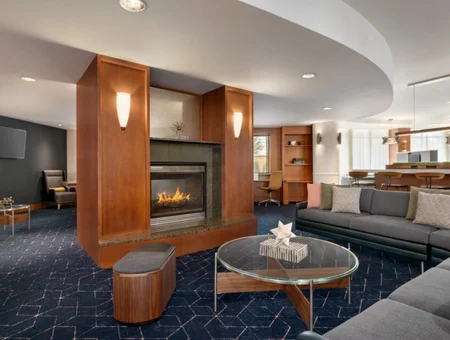 Hotel lounge with a gas fireplace, wood paneling, and lounge seating at Courtyard by Marriott Lancaster