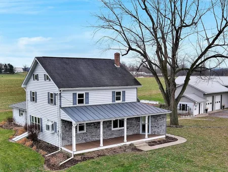 Lancaster County farmhouse with stone porch and metal roof available at auction through L&H Auctions in Lancaster PA