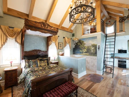Red Caboose Motel suite image: vaulted-ceiling suite with a canopy bed, wood beams, and loft kitchenette at The Red Caboose Motel at Paradise Station in Lancaster, PA