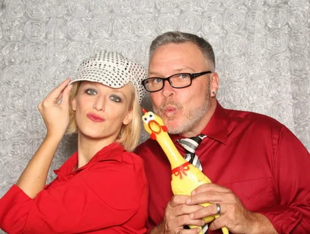 Guests posing with rubber chicken prop at event photo booth by Hey Photobooth in Lancaster PA
