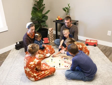 Family playing Amish handcrafted marble board game on floor at AmishToyBox Lancaster PA