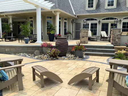 Outdoor patio furniture and Adirondack chairs on travertine patio with pergola by Keystone Outdoor Oasis in Lancaster PA