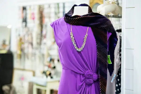 Purple dress with necklace on a mannequin display at Freedom Thrift donated clothing store in Lancaster PA