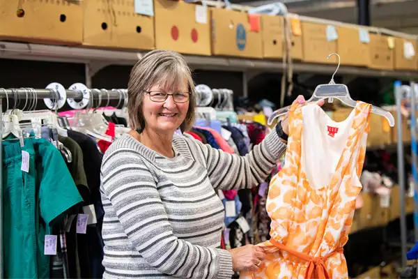 Volunteer sorting donated clothing on racks at Freedom Thrift store in New Holland Lancaster PA