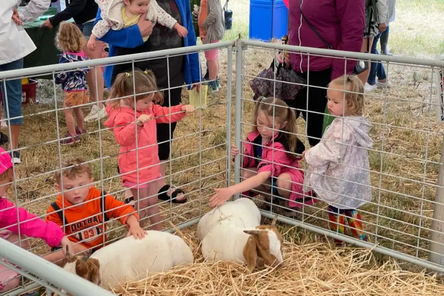 Children petting goats in a petting zoo at Oregon Dairy Farmstead family farm days in Lancaster PA