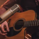 Live acoustic guitar performer with microphone at Lancaster PA music venue