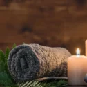 Relaxing spa massage setup with candles, stacked stones, and rolled towel at Massage Inn at Leola, Lancaster PA