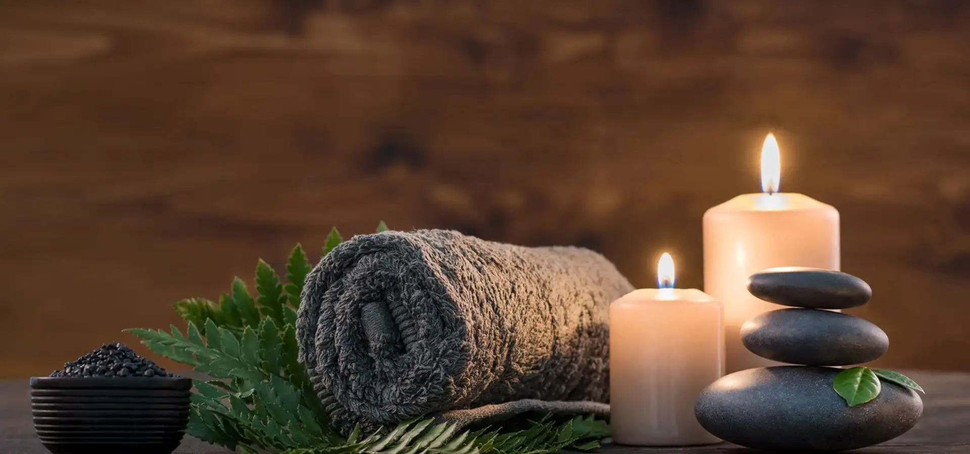 Relaxing spa massage setup with candles, stacked stones, and rolled towel at Massage Inn at Leola, Lancaster PA