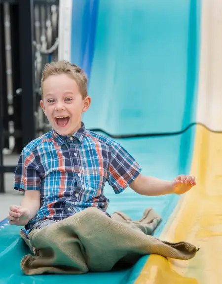 Excited boy riding a giant slide at Dutch Wonderland amusement park in Lancaster PA