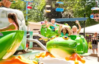 Family riding frog ride at Dutch Wonderland amusement park in Lancaster PA