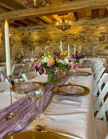 The Barn at Paradise Station rustic stone wedding banquet hall with floral centerpieces and candlelight - Lancaster PA