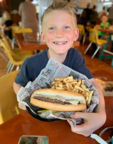 Happy child holding burger and fries at Shack Restaurant birthday celebration - family dining Lancaster PA