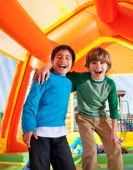 Two boys laughing inside an inflatable bounce house at a kids party venue in Lancaster PA