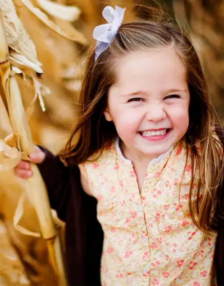 Happy young girl in a corn stalk display at Cherry Crest Adventure Farm in Ronks Lancaster County PA