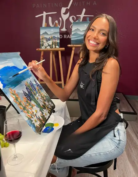 Woman painting a canvas with wine at a Painting with a Twist class in Lancaster PA