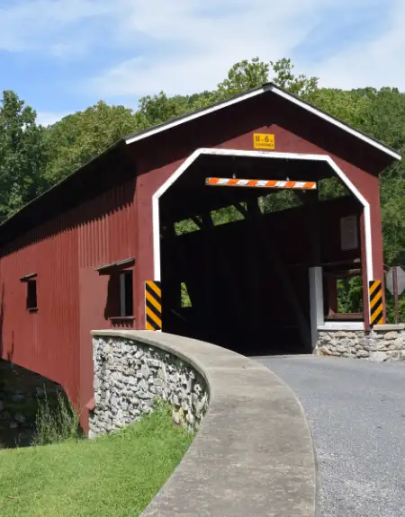 Historic red covered bridge over a stream in Lancaster County PA