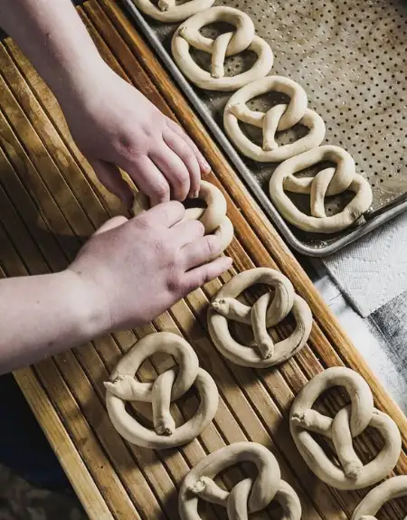 Hands rolling soft pretzels by hand on a factory tour at Julius Sturgis Pretzel Bakery in Lititz Lancaster County PA