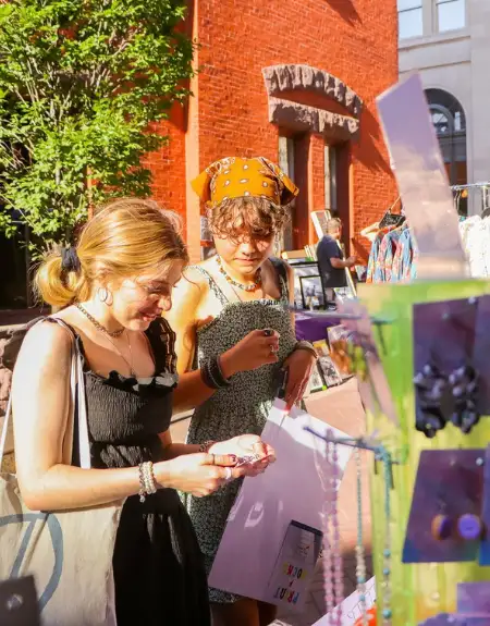 People browsing an outdoor art vendor market on a Friday in downtown Lancaster City PA
