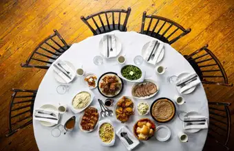 Plain and Fancy Farm family style group dining table overhead view with shared dishes - Lancaster PA restaurant
