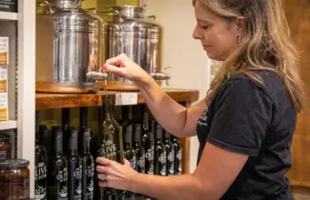 Woman sampling olive oil at a specialty shop, indoor shopping in Lancaster PA