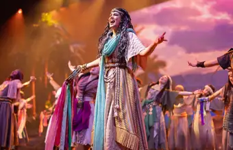 Female lead performer on stage in a colorful theatrical production, indoor theater in Lancaster PA