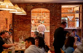 Passerine Restaurant Lancaster City dining room with exposed brick and open kitchen - Lancaster PA