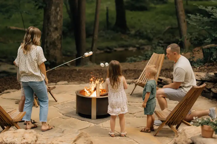 Family enjoying a custom stone patio fire pit in Lancaster PA, outdoor hardscaping by Luxscapes Unlimited
