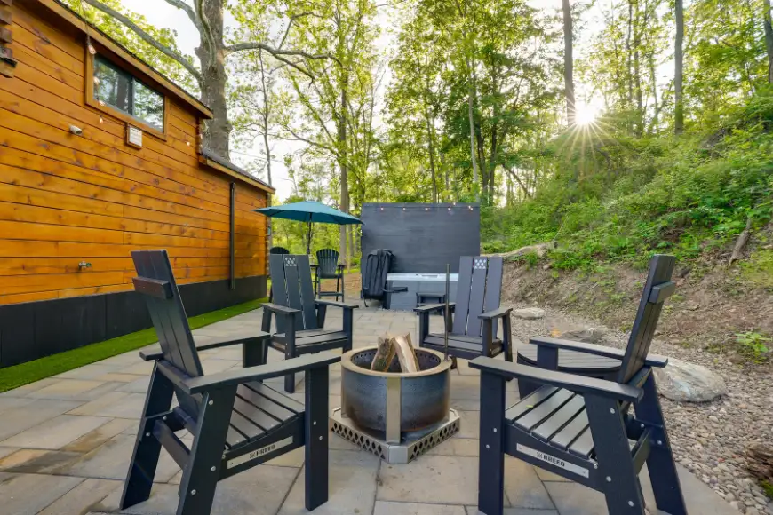 Outdoor patio with fire pit and Adirondack chairs beside a wood cabin in Lancaster PA by Luxscapes Unlimited