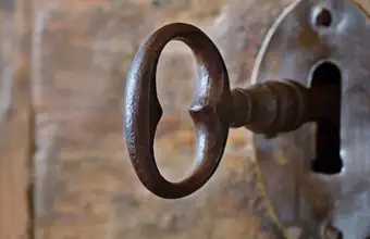 Vintage iron key in a lock for an escape room experience in Lancaster PA