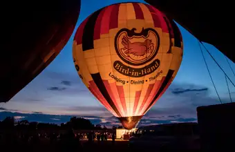 Bird-in-Hand hot air balloon glowing at dusk, balloon rides in Lancaster PA