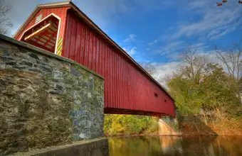 Historic red covered bridge over a creek in Lancaster County PA