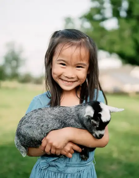 Young girl holding a baby goat at Verdant View Farm petting zoo in Lancaster County PA