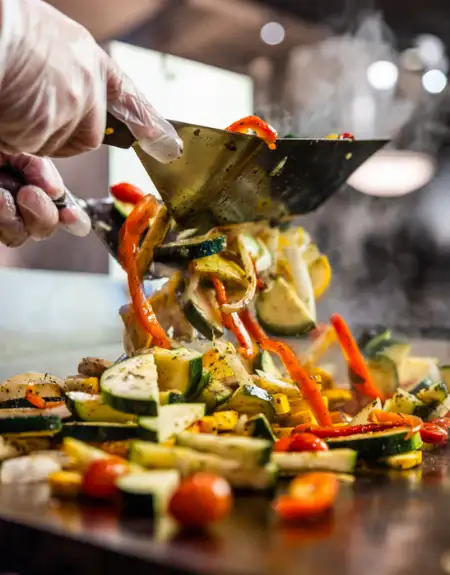 Chef cooking stir fried vegetables on flat top grill - Shack Restaurant Lancaster PA