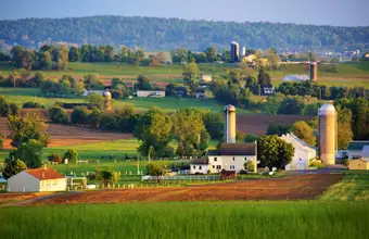Aerial view of Lancaster County PA farmland with silos and rolling fields