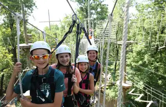 Family wearing helmets on a zip line or ropes course outdoor adventure in Lancaster PA