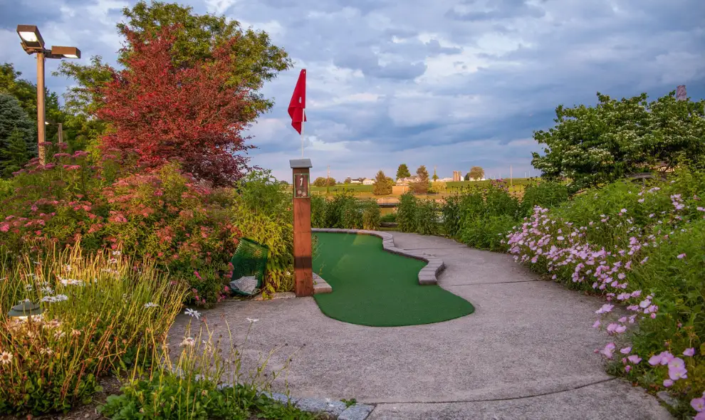 Waters Edge Mini Golf course hole with landscaping and red flag - Lancaster PA miniature golf